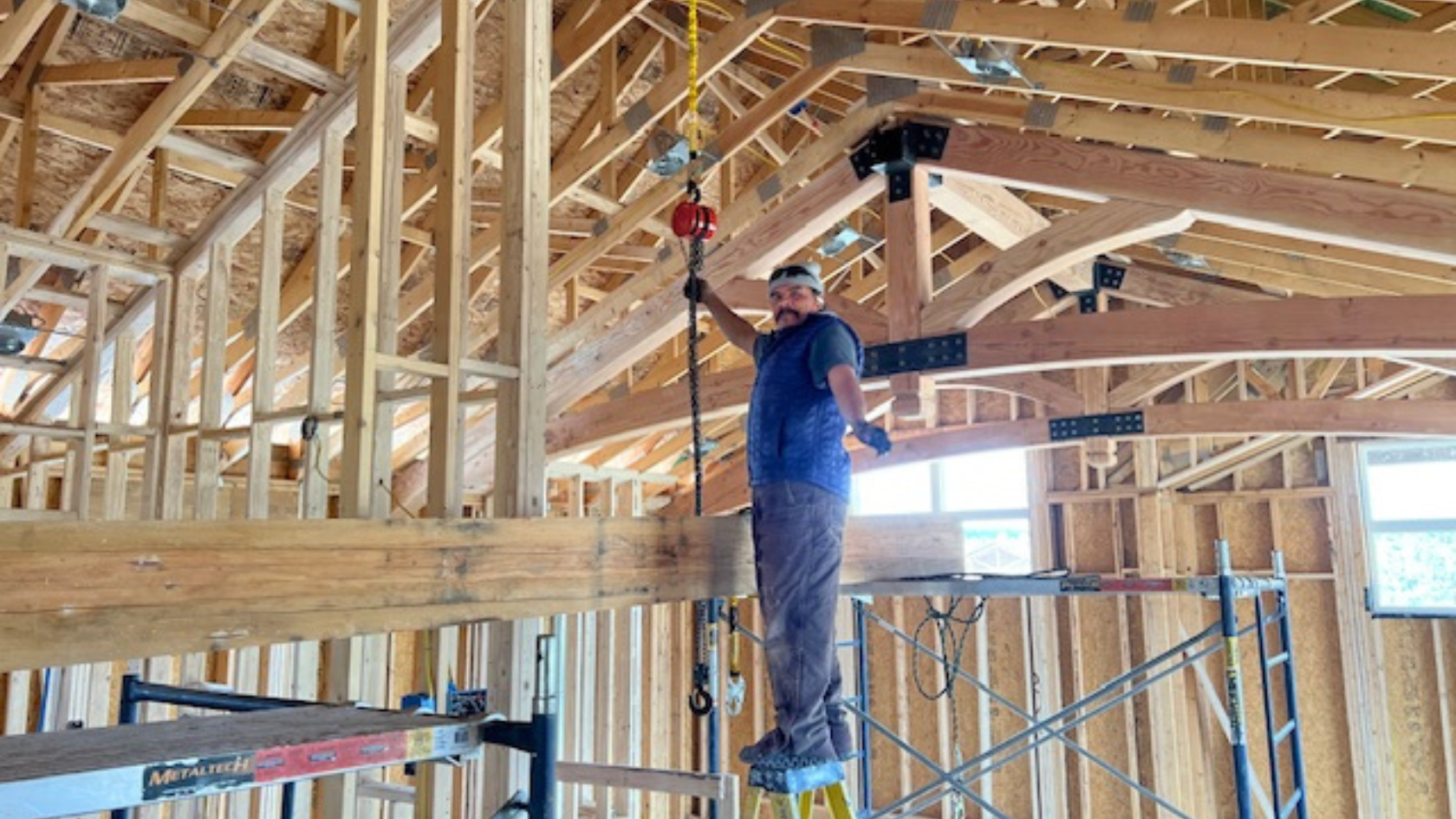 A man standing on a scaffold in a building under construction