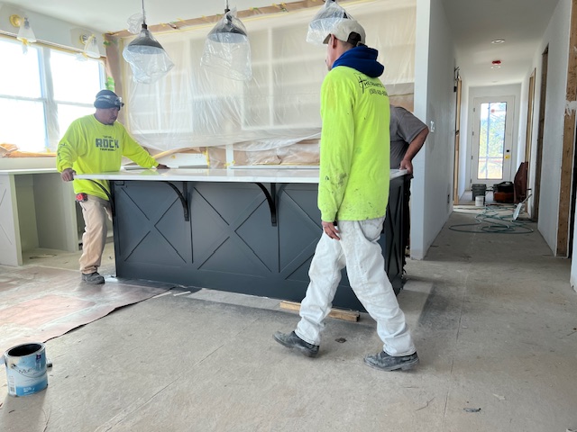 A couple of men standing in a kitchen under construction